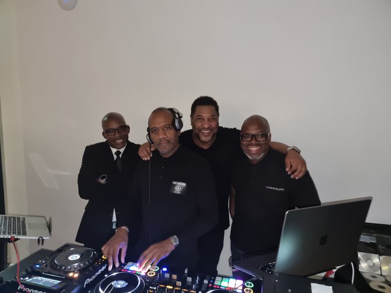 The Qudos Audio DJ team posing behind Pioneer DJ decks